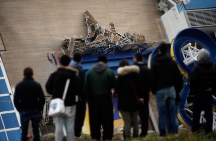 People look at the deck chairs piled on the deck of the leaning Costa Concordia, on January 15, 2012, after the cruise ship ran aground on January 13. (Filippo Monteforte/AFP/Getty Images)
