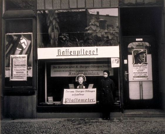 Nazi propaganda in Berlin storefront, including anthropometric device for measuring differences between Aryan and Non-Aryan skulls